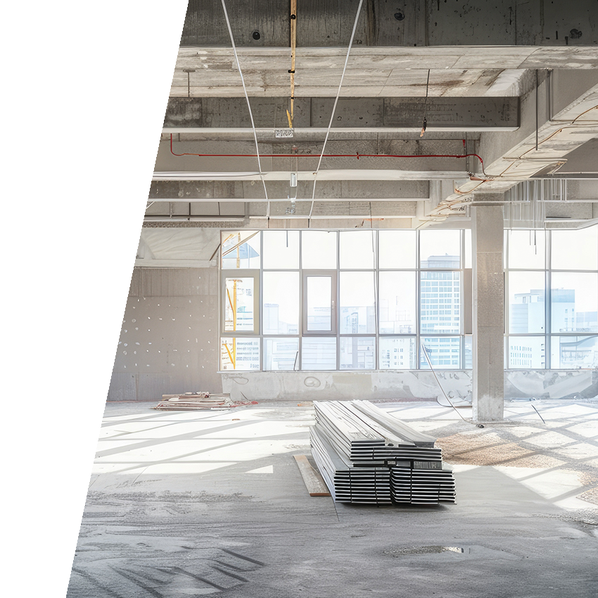 Commercial construction project with drywall installed and neatly stacked pile of panels in the center of the room.